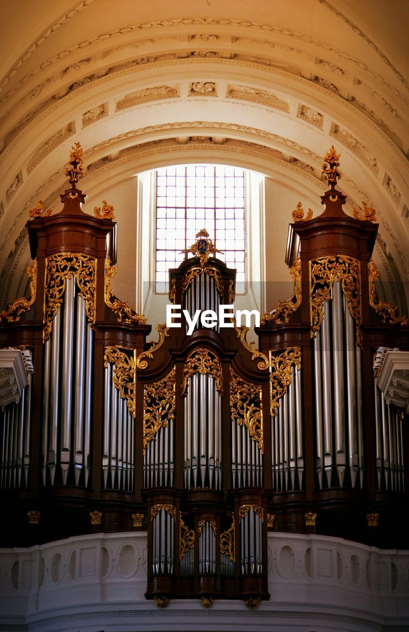 Low angle view of pipe organ in old church