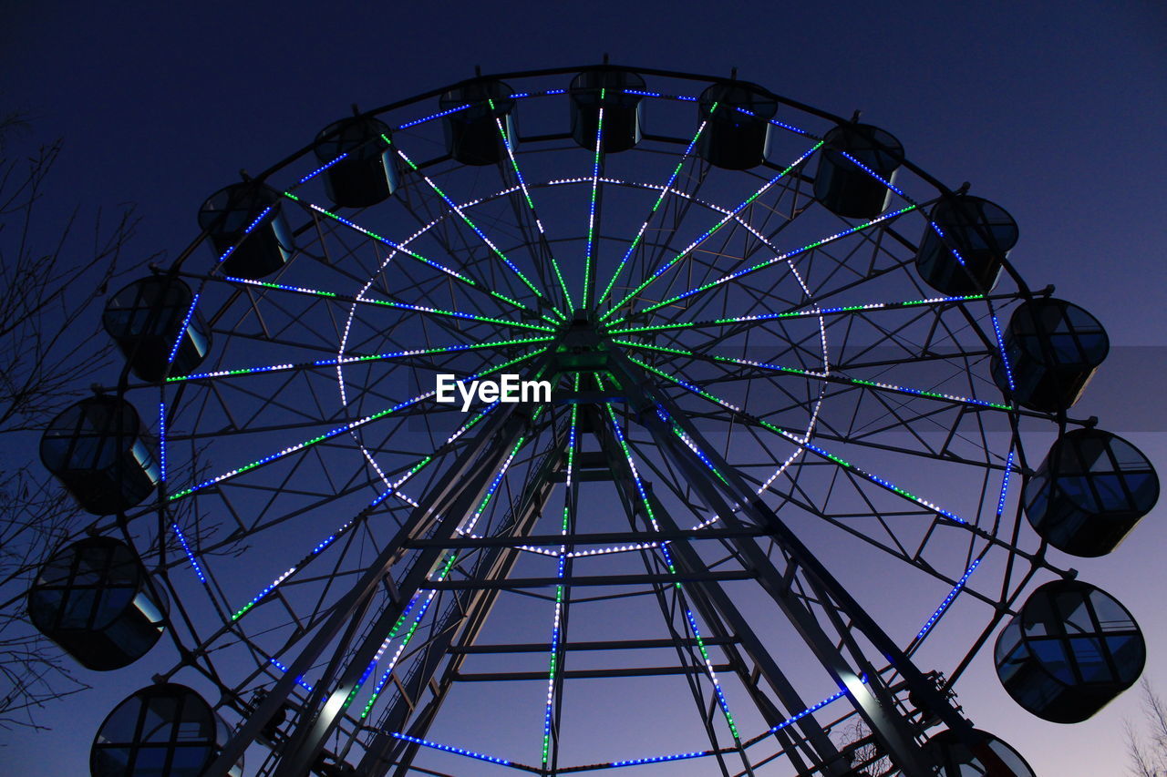 ferris wheel, amusement park ride, amusement park, arts culture and entertainment, sky, geometric shape, circle, low angle view, carnival, shape, traveling carnival, recreation, fun, blue, no people, nature, clear sky, architecture, leisure activity, spinning, night, wheel, enjoyment, built structure, outdoors, travel destinations, illuminated