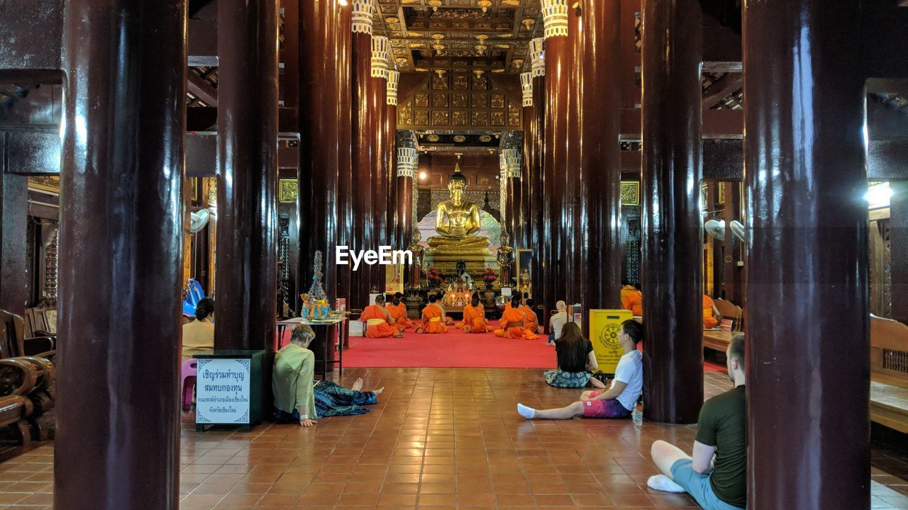 People meditating in buddhist temple