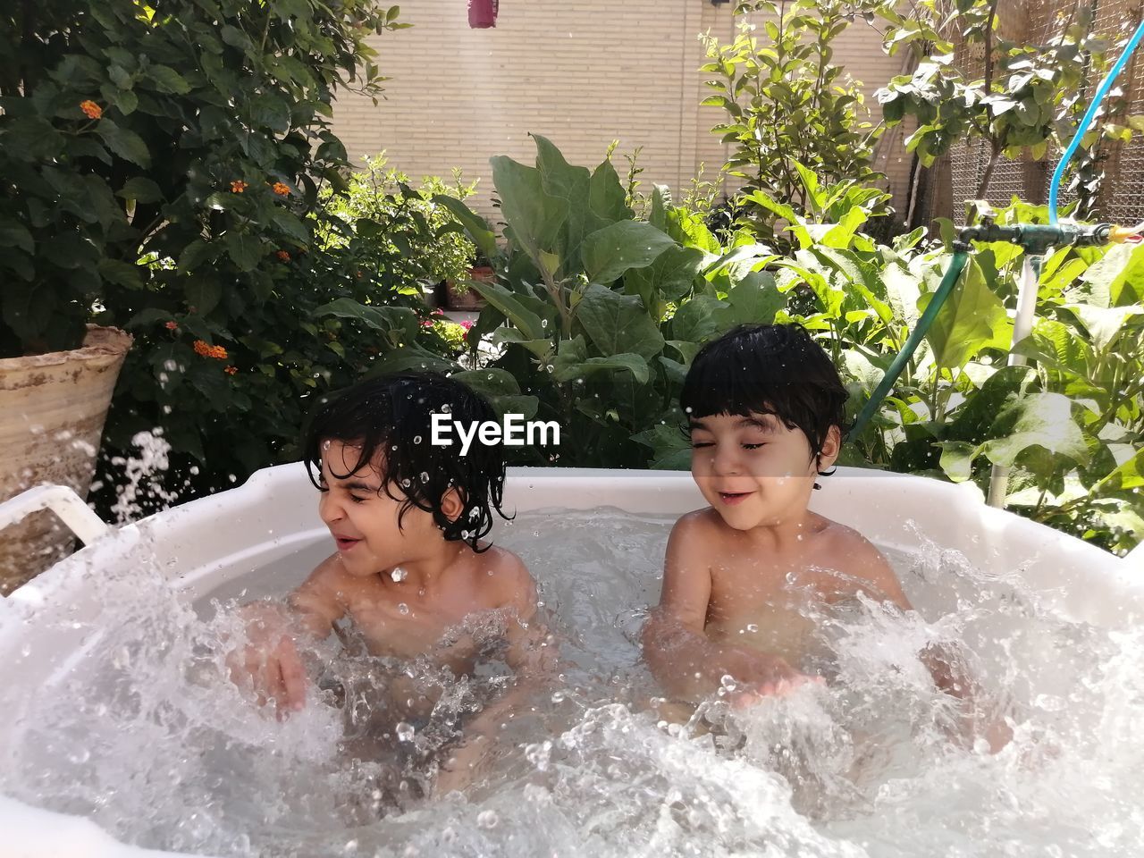 High angle view of kids playing in bathtub outdoors