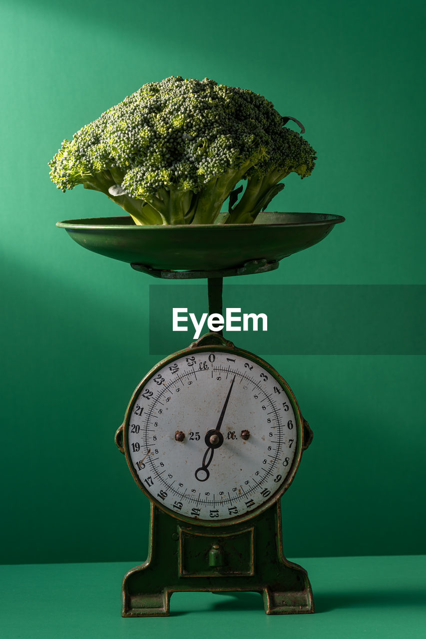 Close-up of broccoli on table against wall