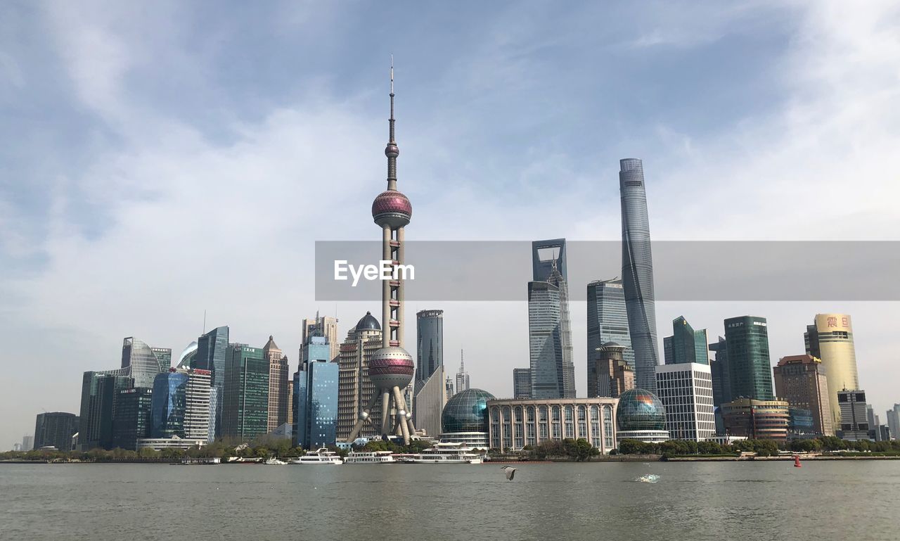 View of buildings in city against cloudy sky