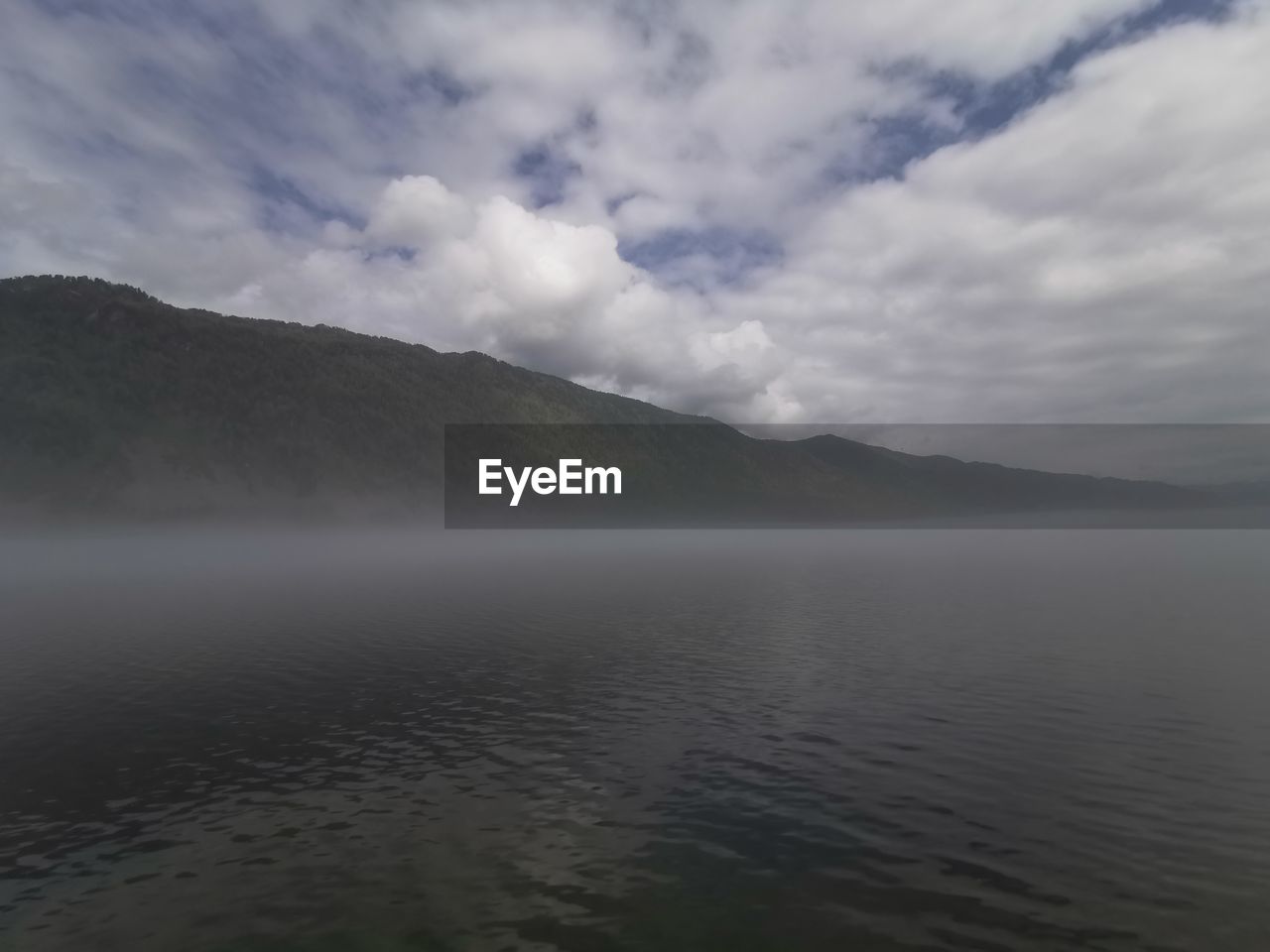 SCENIC VIEW OF SEA AGAINST MOUNTAINS