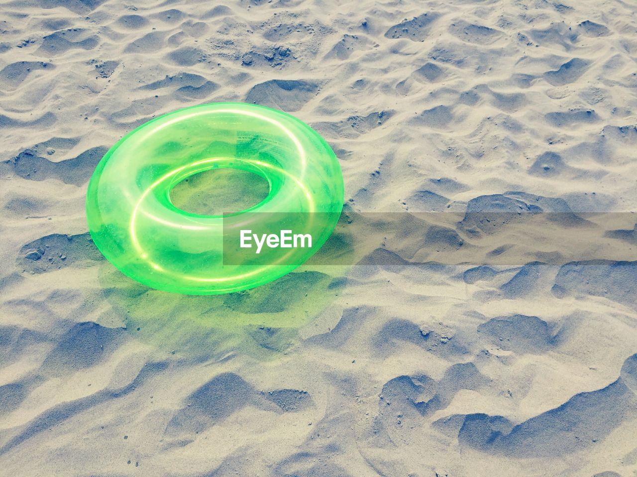 High angle view of green lifeguard ring on sand at beach