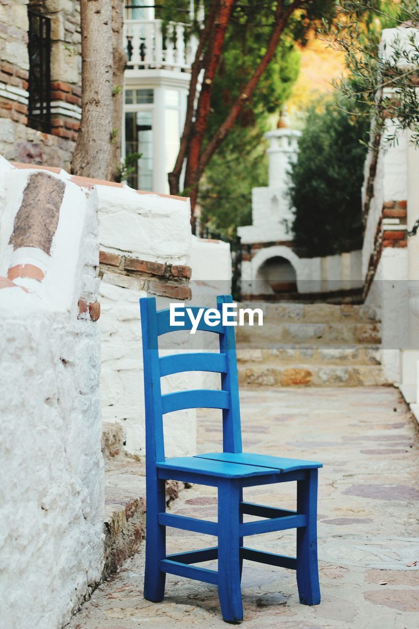 Blue wooden chair on footpath