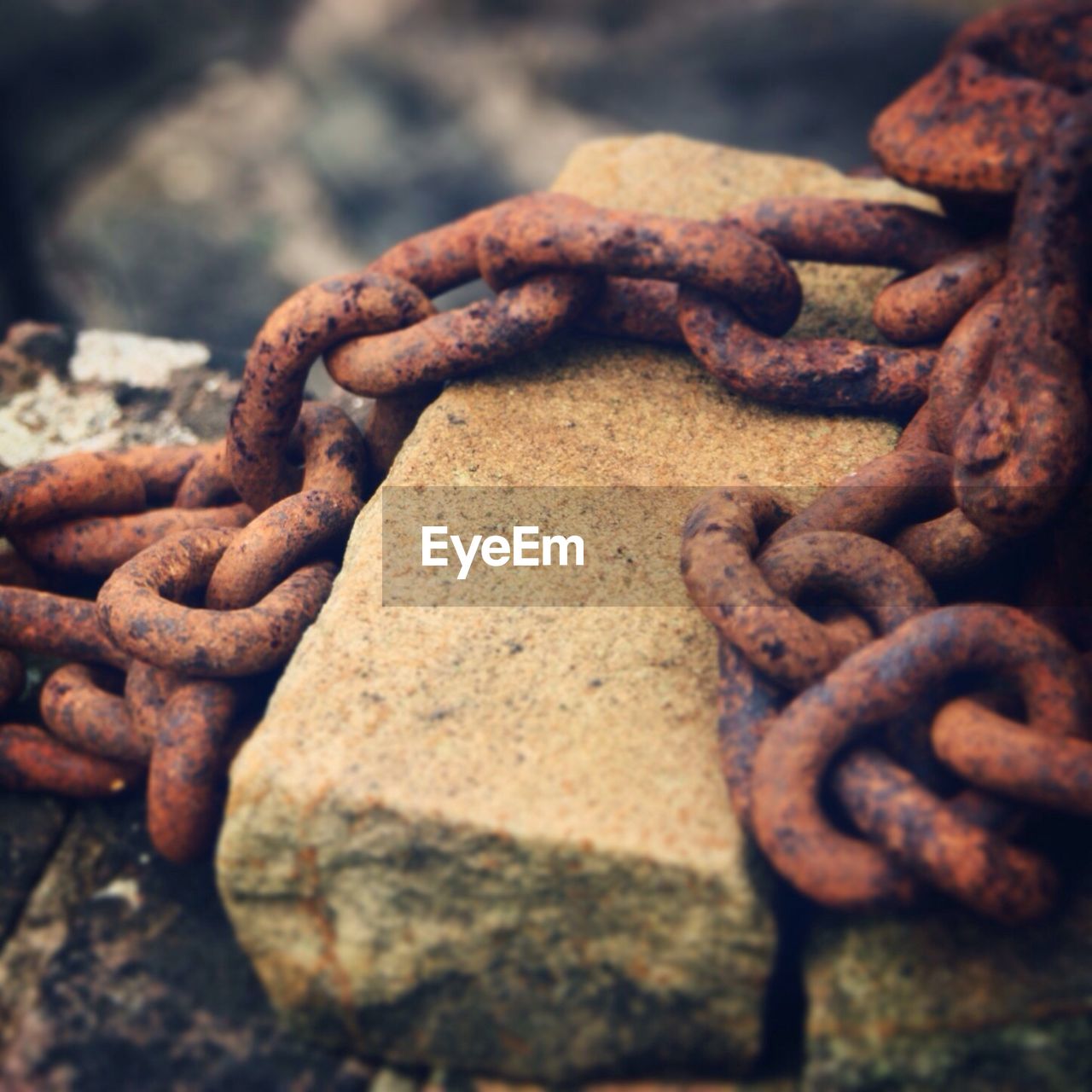 Close-up of rusty chain on stones