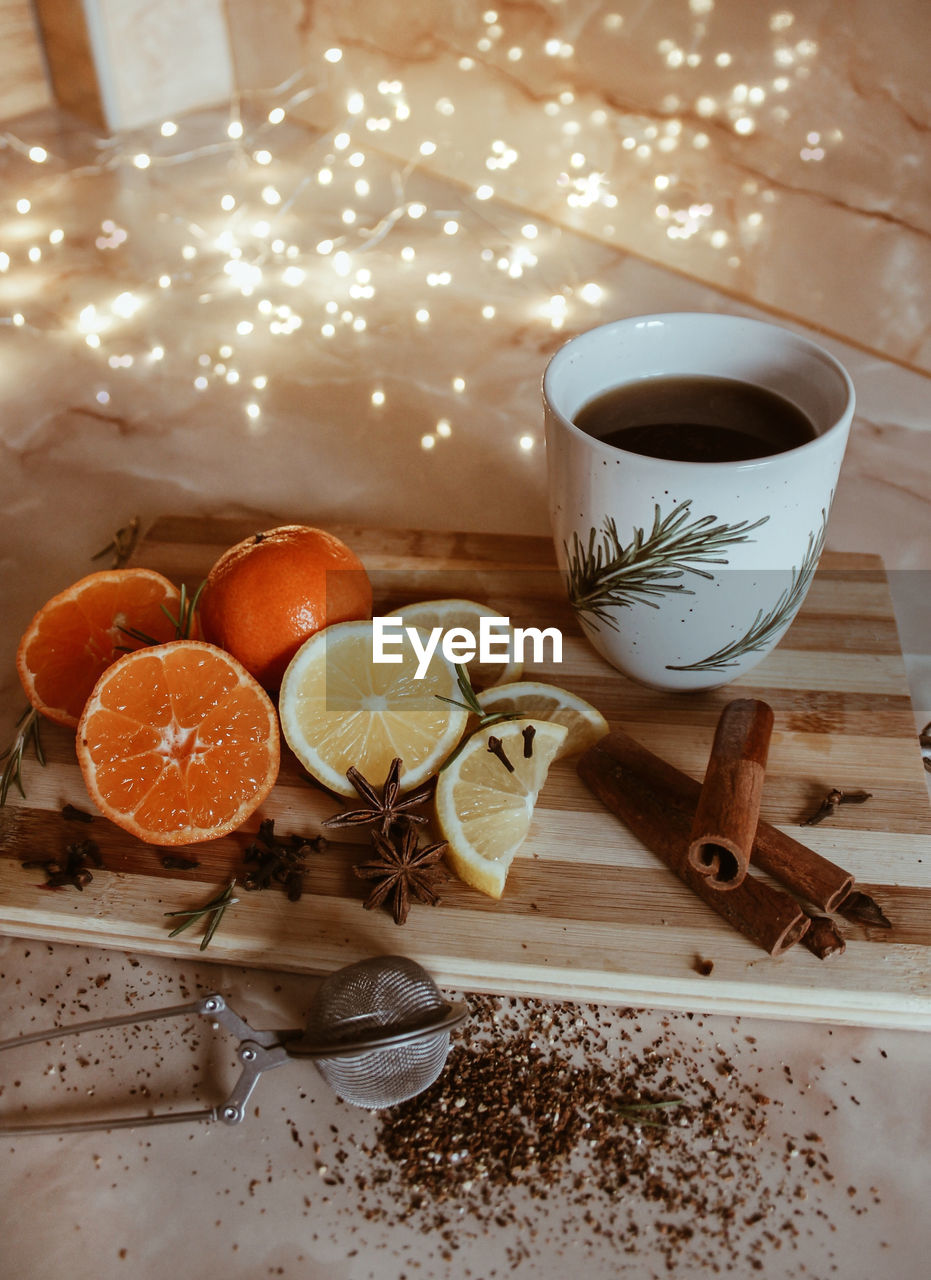 High angle view of fruits by coffee cup on table