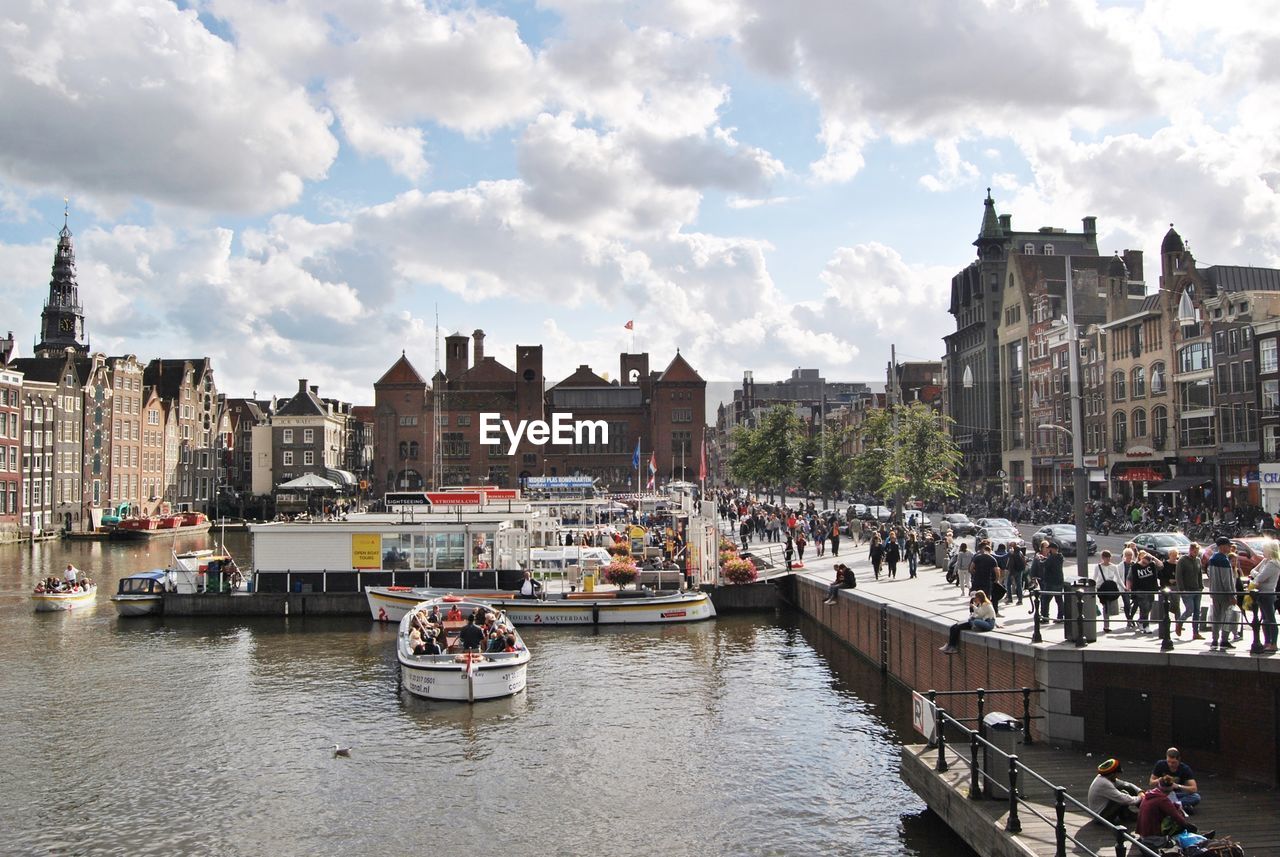 BOATS IN RIVER WITH CITYSCAPE IN BACKGROUND