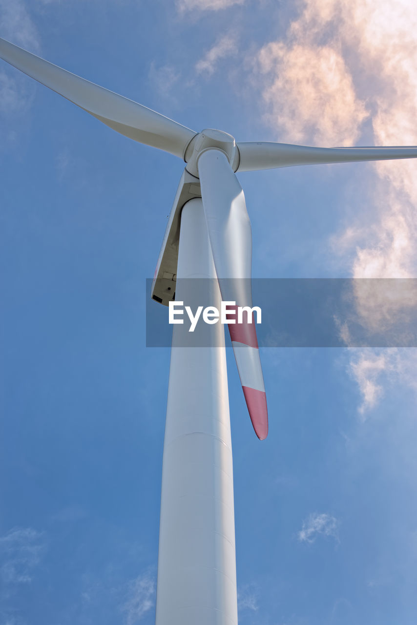 Low angle view of windmill against blue sky