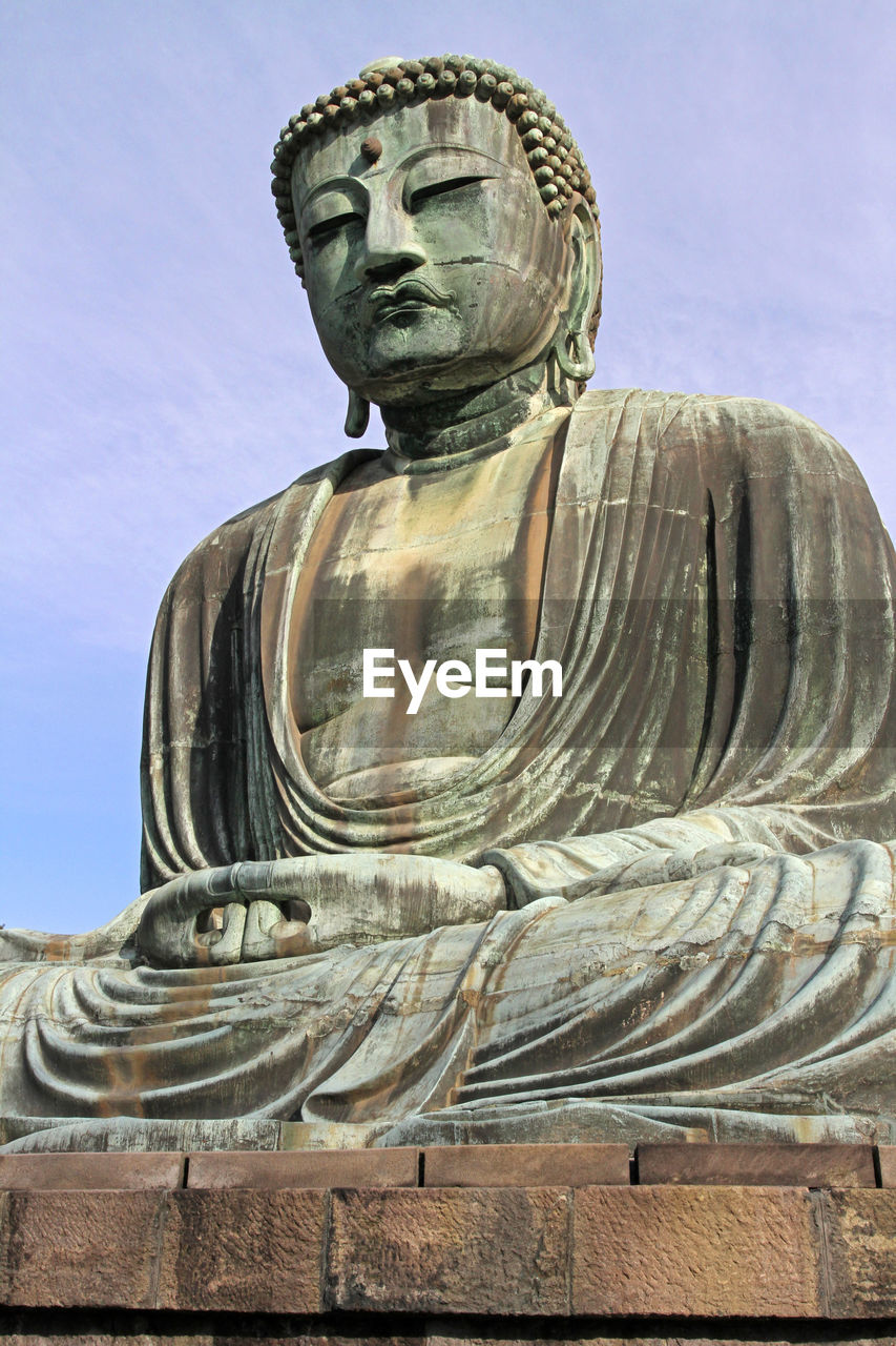 LOW ANGLE VIEW OF A STATUE OF A BUDDHA