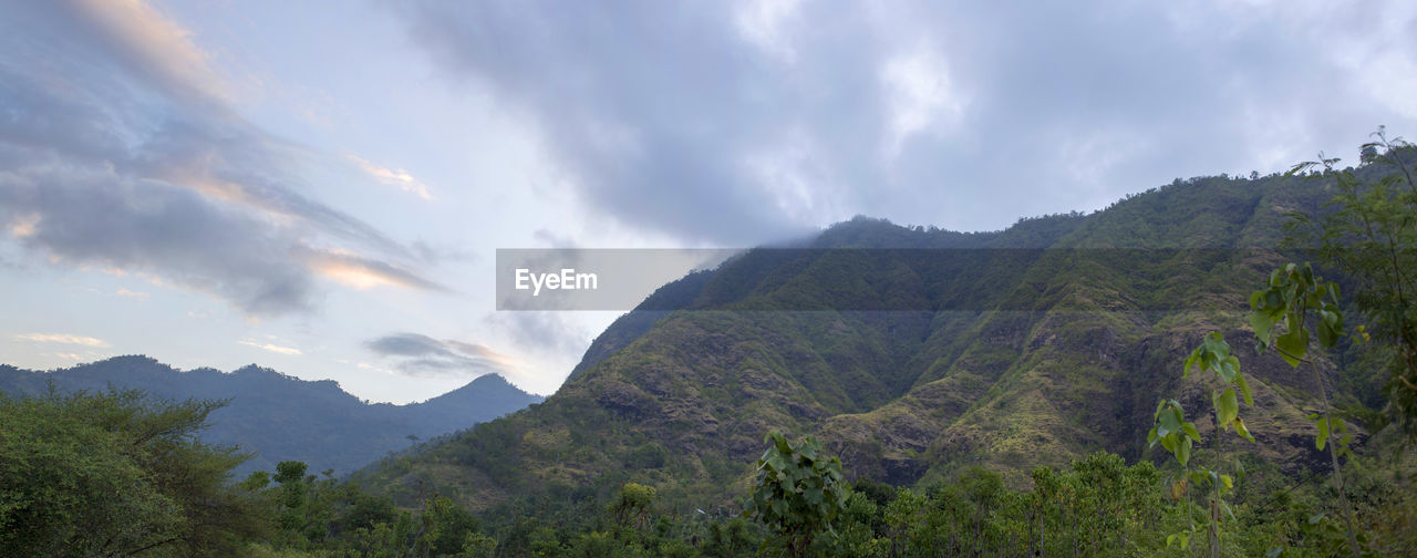 Low angle view of mountain against cloudy sky