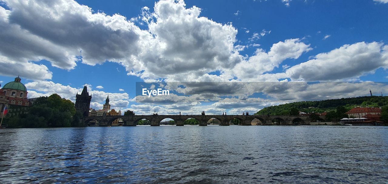 BRIDGE OVER RIVER AGAINST BUILDINGS IN CITY