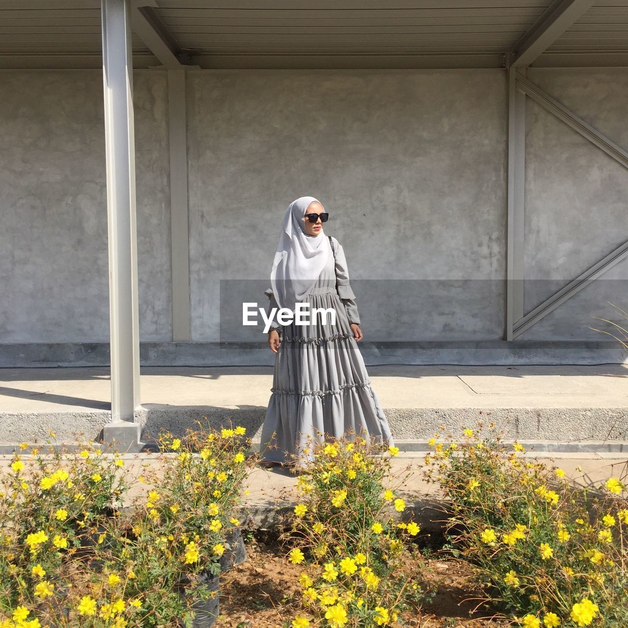 Full length of woman standing on flowering plants