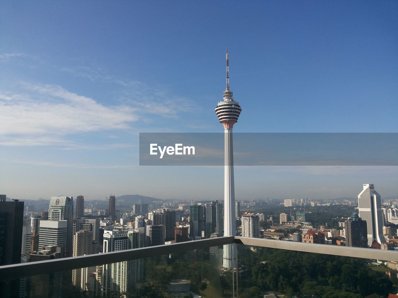 Communications tower in city against sky