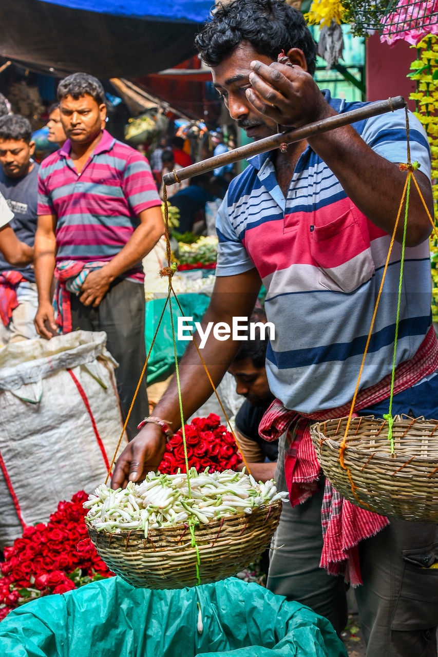 GROUP OF PEOPLE IN MARKET STALL