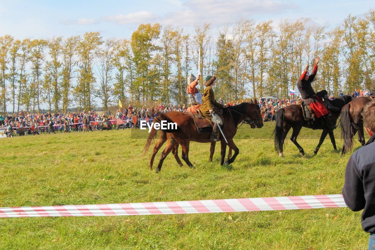 HORSE RUNNING ON FIELD AGAINST SKY