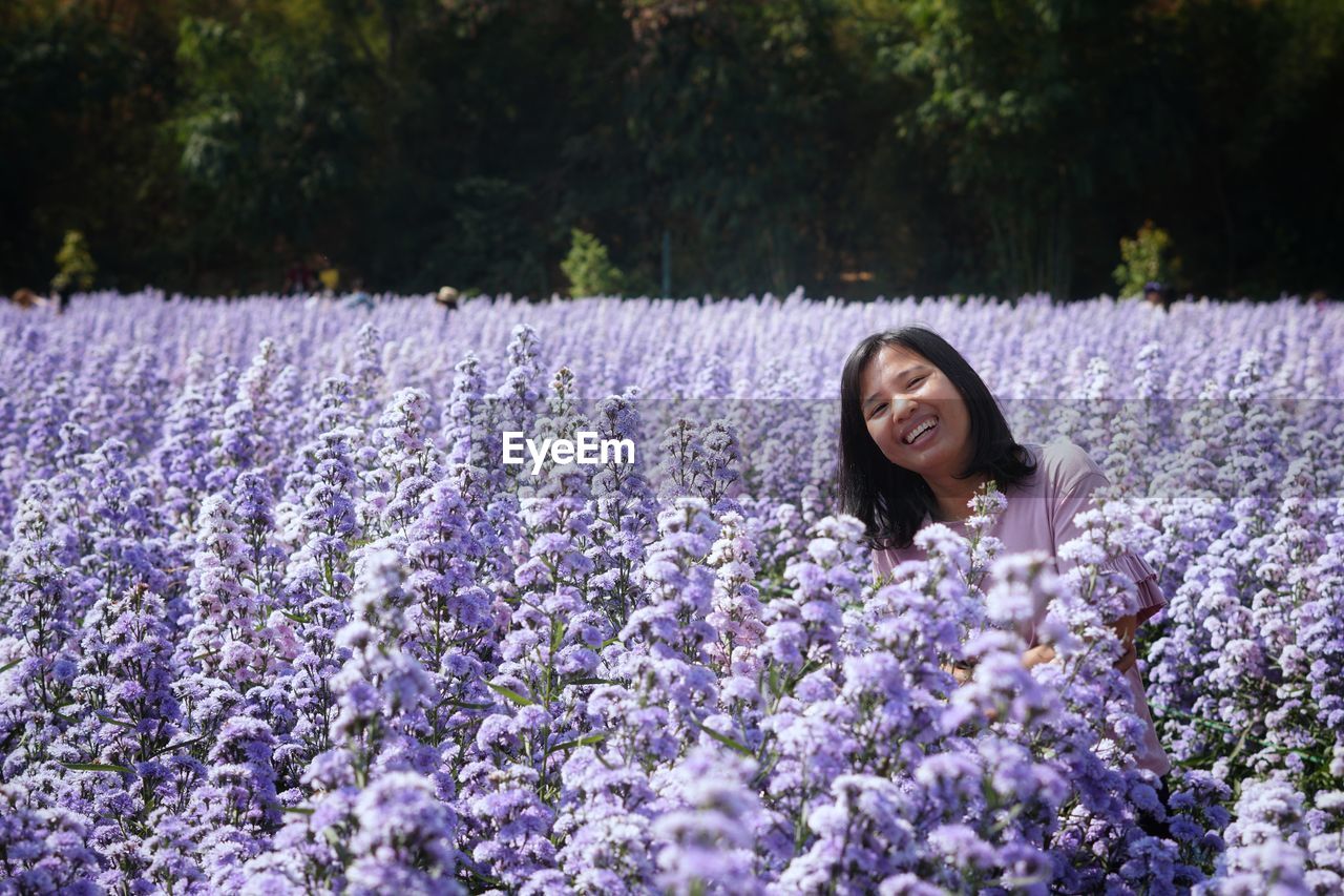 Woman with pink flowers on field