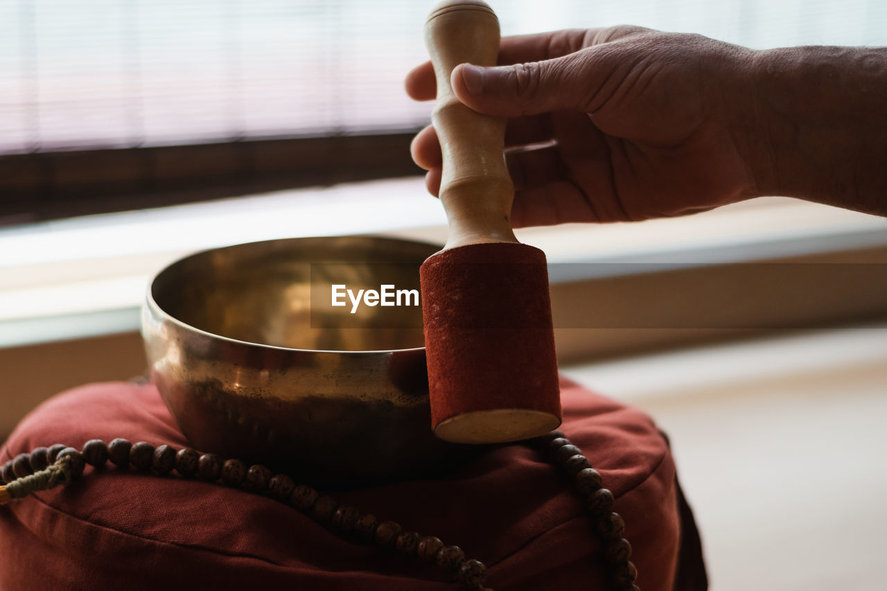 Man's hands holding and playing with a beautiful tibetan bowl