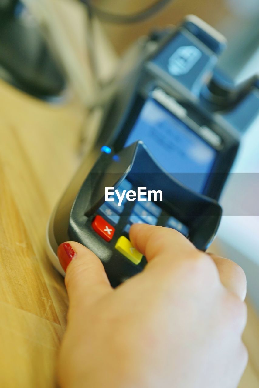 Close-up of woman using credit card reader