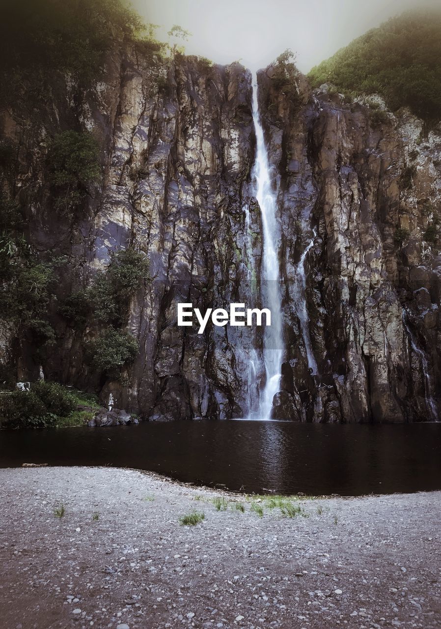 Scenic view of waterfall against sky