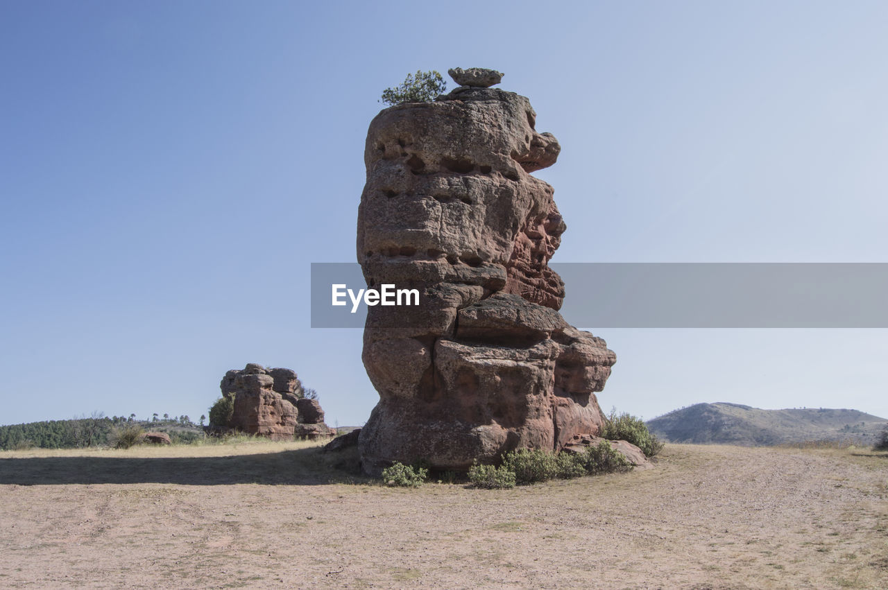 Stack rock on field against clear blue sky at parque natural del alto tajo