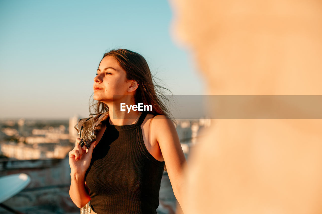 BEAUTIFUL WOMAN STANDING AGAINST SKY