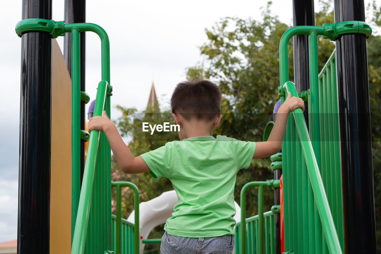 Rear view of boy playing in ground