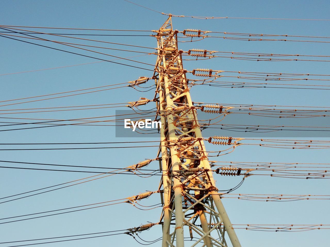 Low angle view of electricity pylon against clear sky