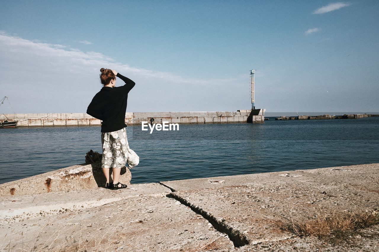 Full length of woman standing at promenade against sky