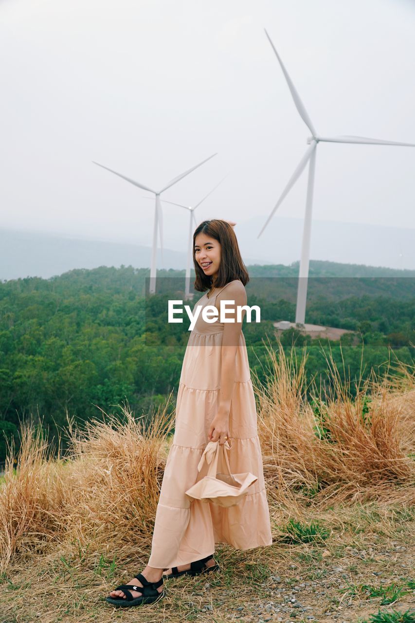 Woman standing on field against sky