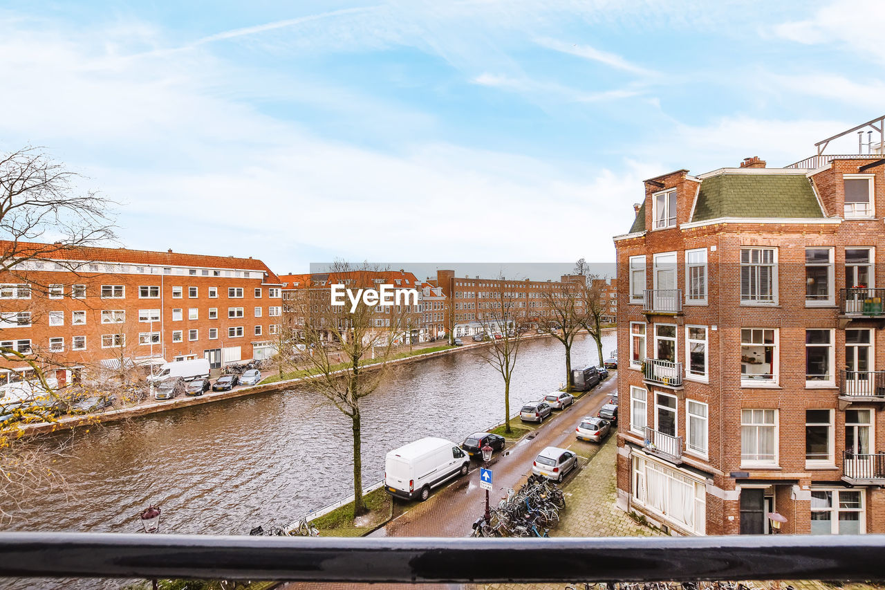 CANAL AMIDST BUILDINGS AGAINST SKY