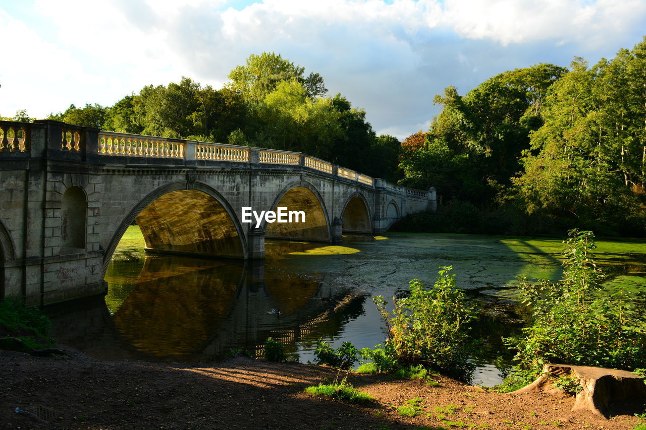 bridge, water, architecture, river, built structure, plant, arch bridge, arch, nature, tree, cloud, sky, transportation, reflection, autumn, no people, waterway, travel destinations, outdoors, rural area, environment, landscape, city, day, travel, history, flower, the past