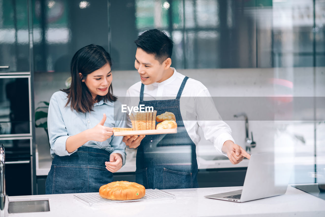 Young man and woman working in bakery