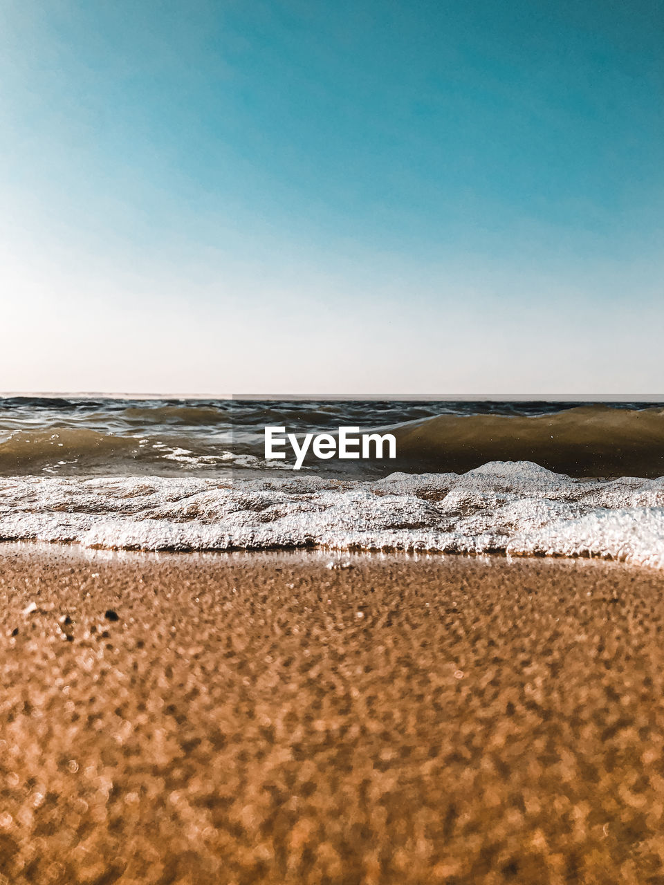 Surface level of beach against clear sky