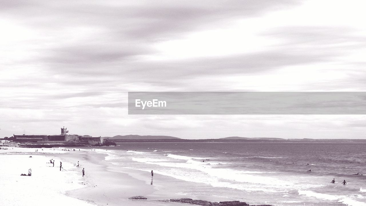 Scenic view of beach against cloudy sky