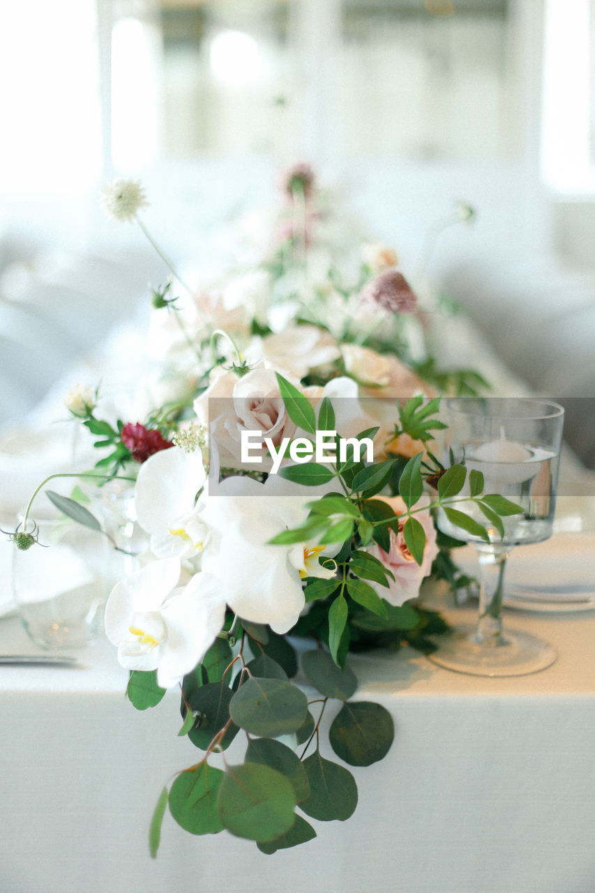 CLOSE-UP OF WHITE ROSES ON TABLE