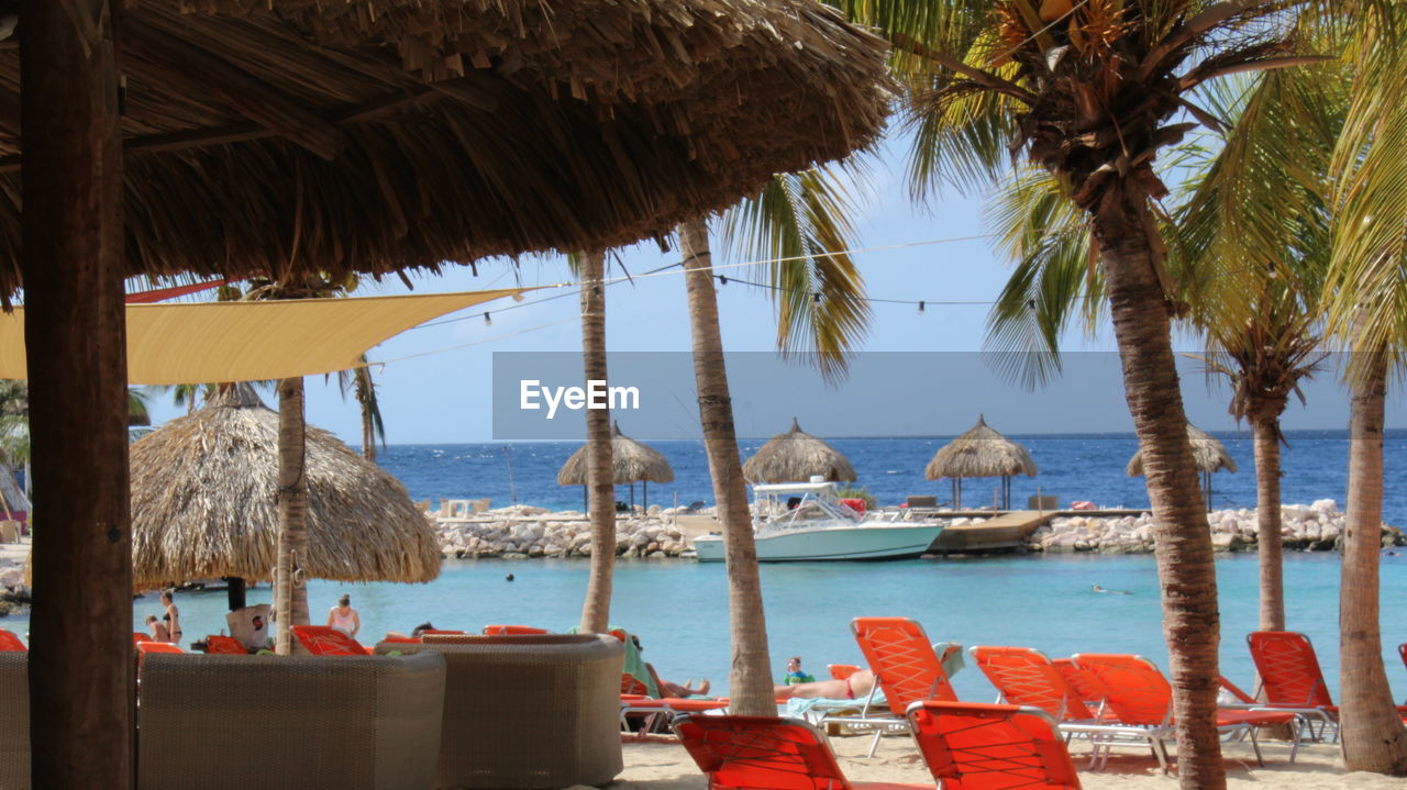 Deck chairs and thatched roof parasols at beach