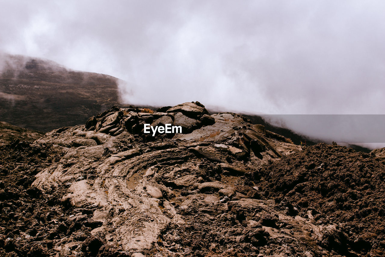 Smoke emitting from volcanic mountain against sky