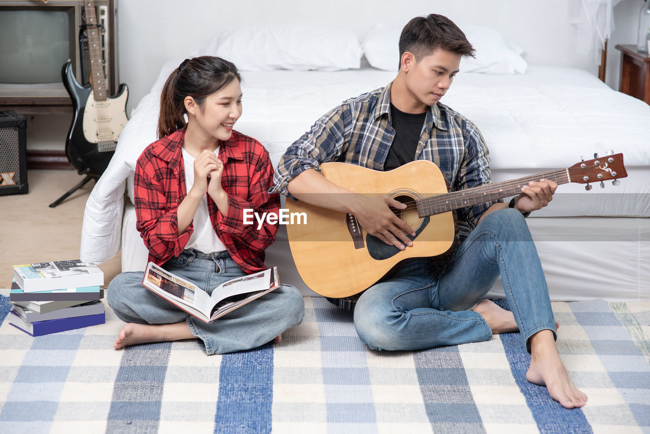 YOUNG COUPLE PLAYING GUITAR AT CONCERT