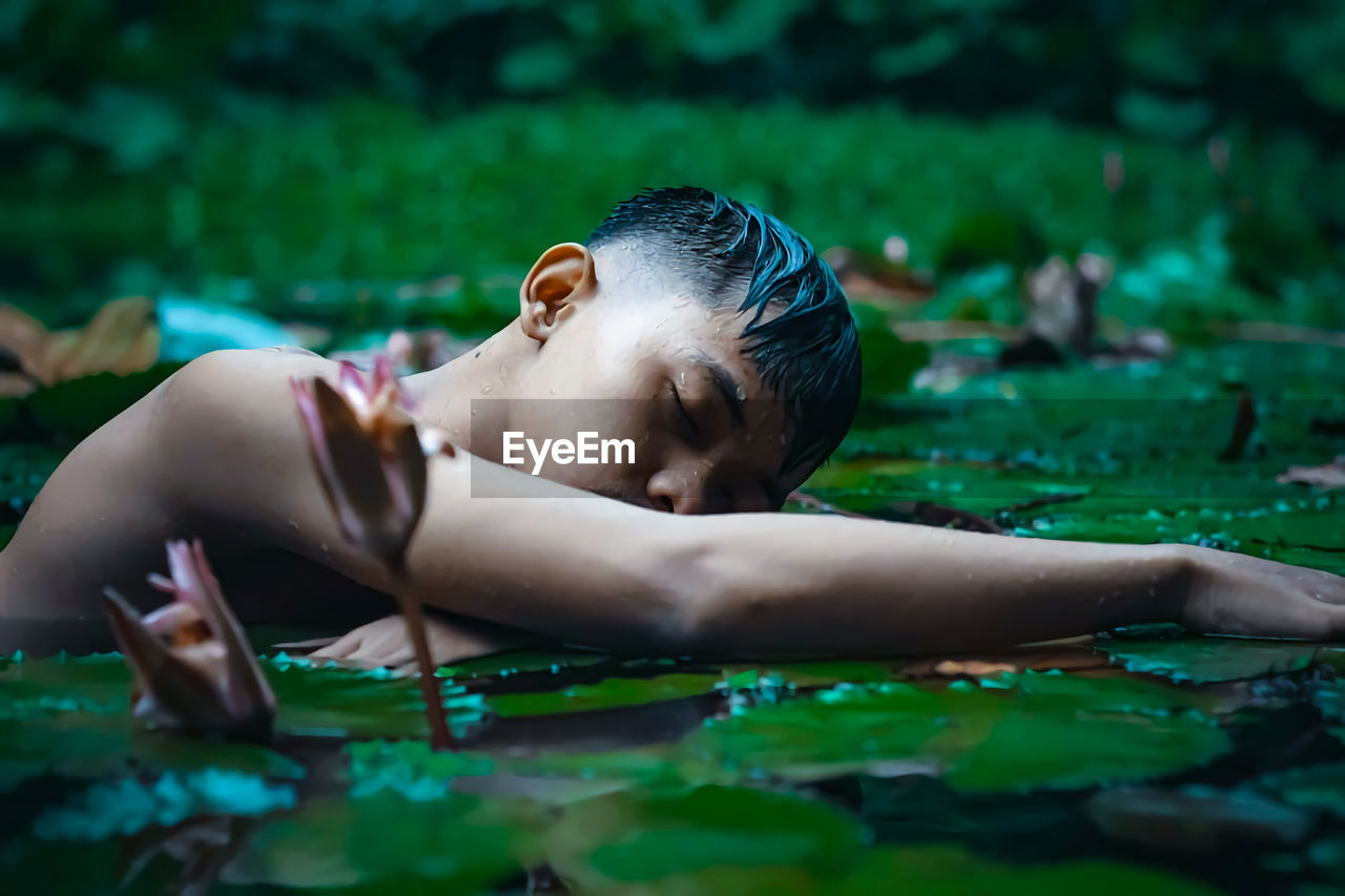 Young shirtless man relaxing in lake