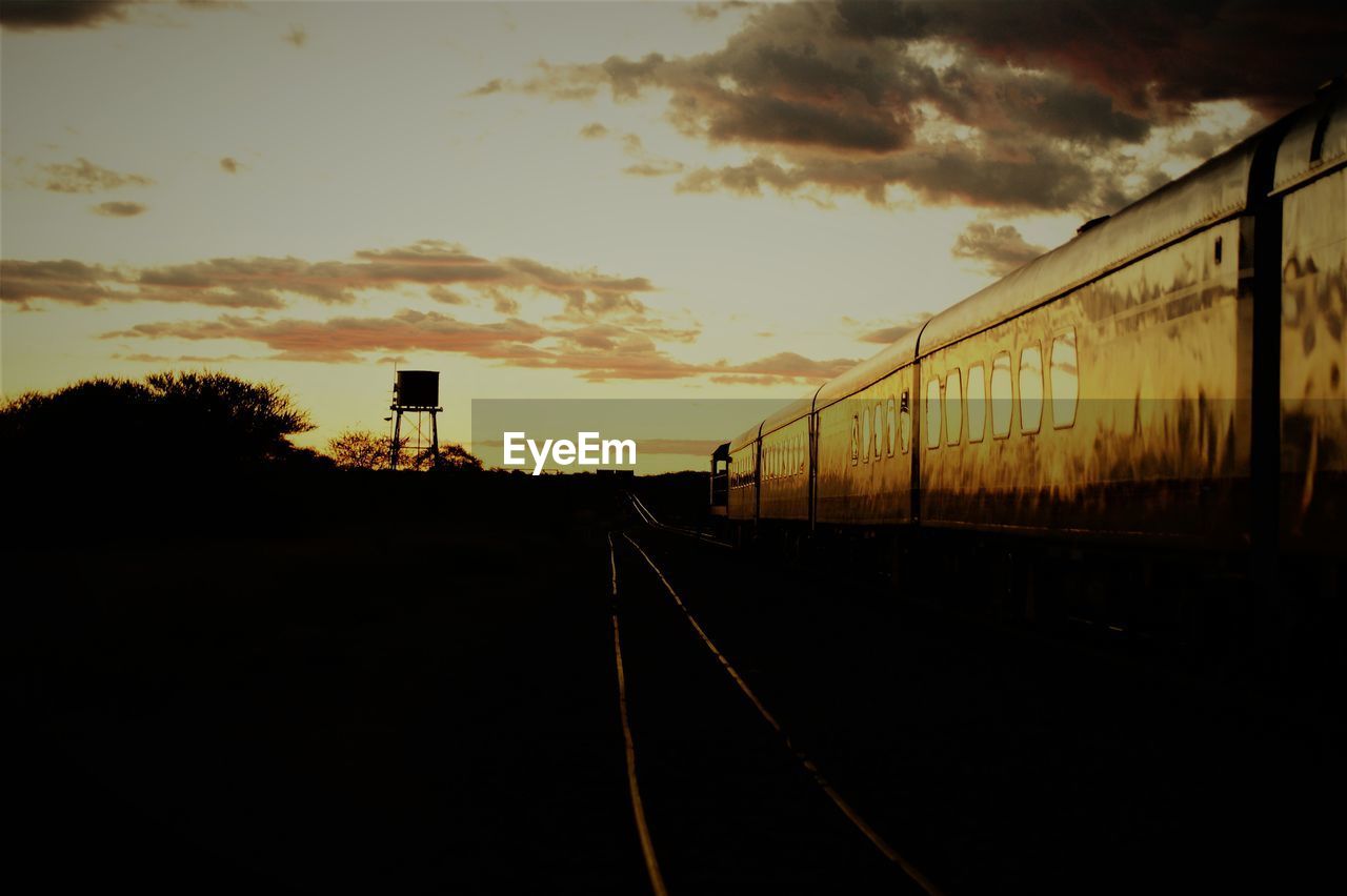 SILHOUETTE OF RAILROAD TRACKS AGAINST SKY