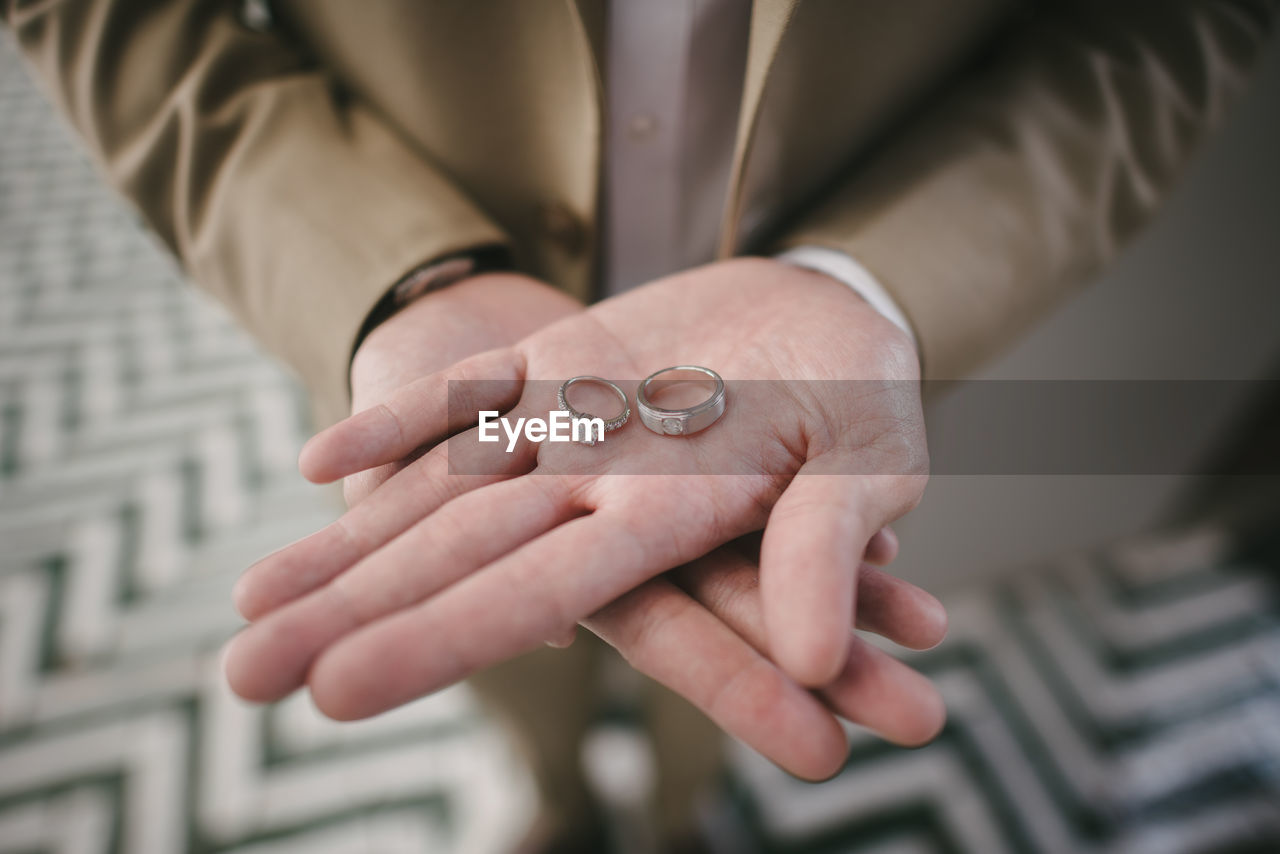 Midsection of bride holding wedding rings