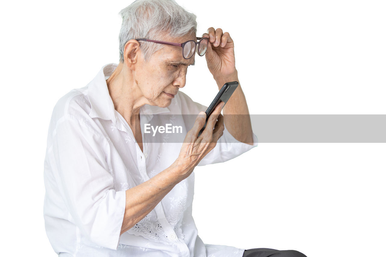 adult, one person, white background, senior adult, cut out, men, person, gray hair, indoors, hand, arm, eyeglasses, glasses, studio shot, looking, white, holding, seniors, relaxation, lifestyles, waist up, copy space, clothing, mature adult, casual clothing, finger, occupation, portrait, activity
