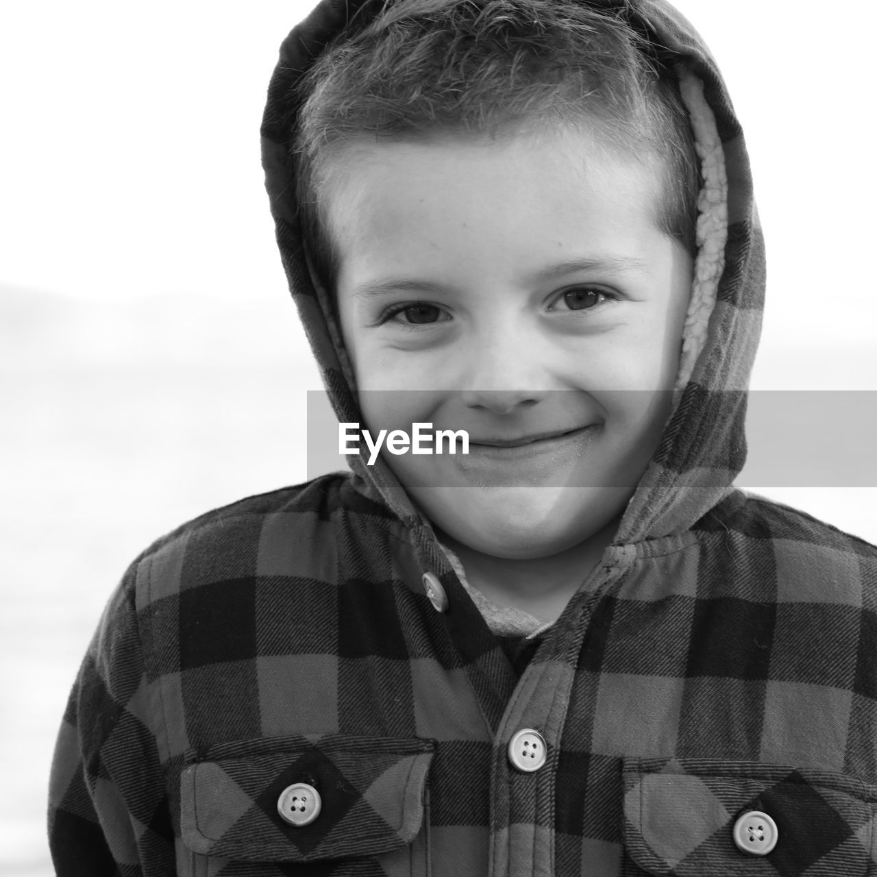 Black and white sweet little boy in hooded jacket 