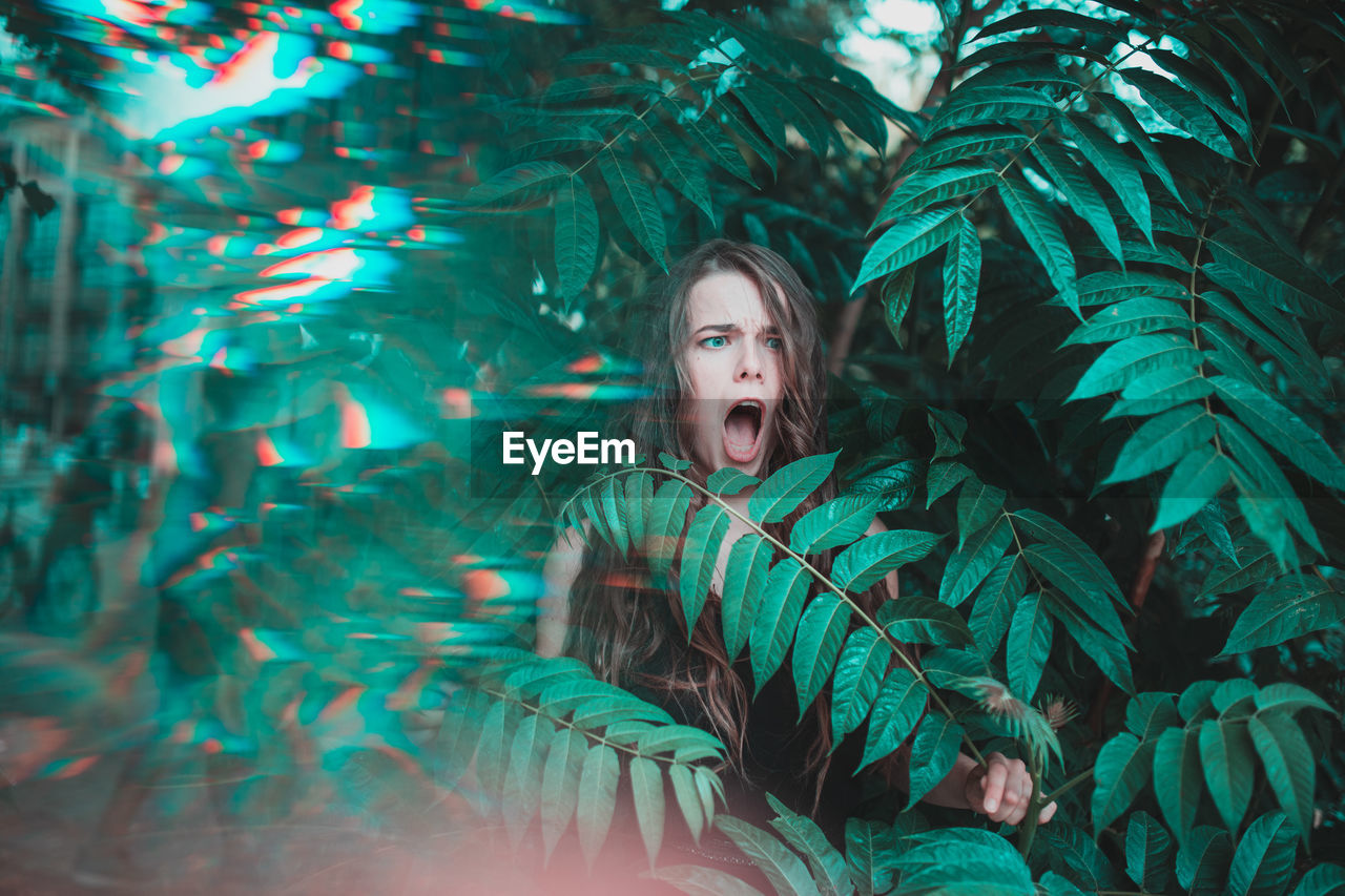 Young woman standing amidst plants