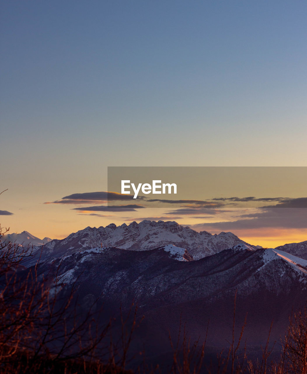 Scenic view of snowcapped mountains against clear sky during dawn