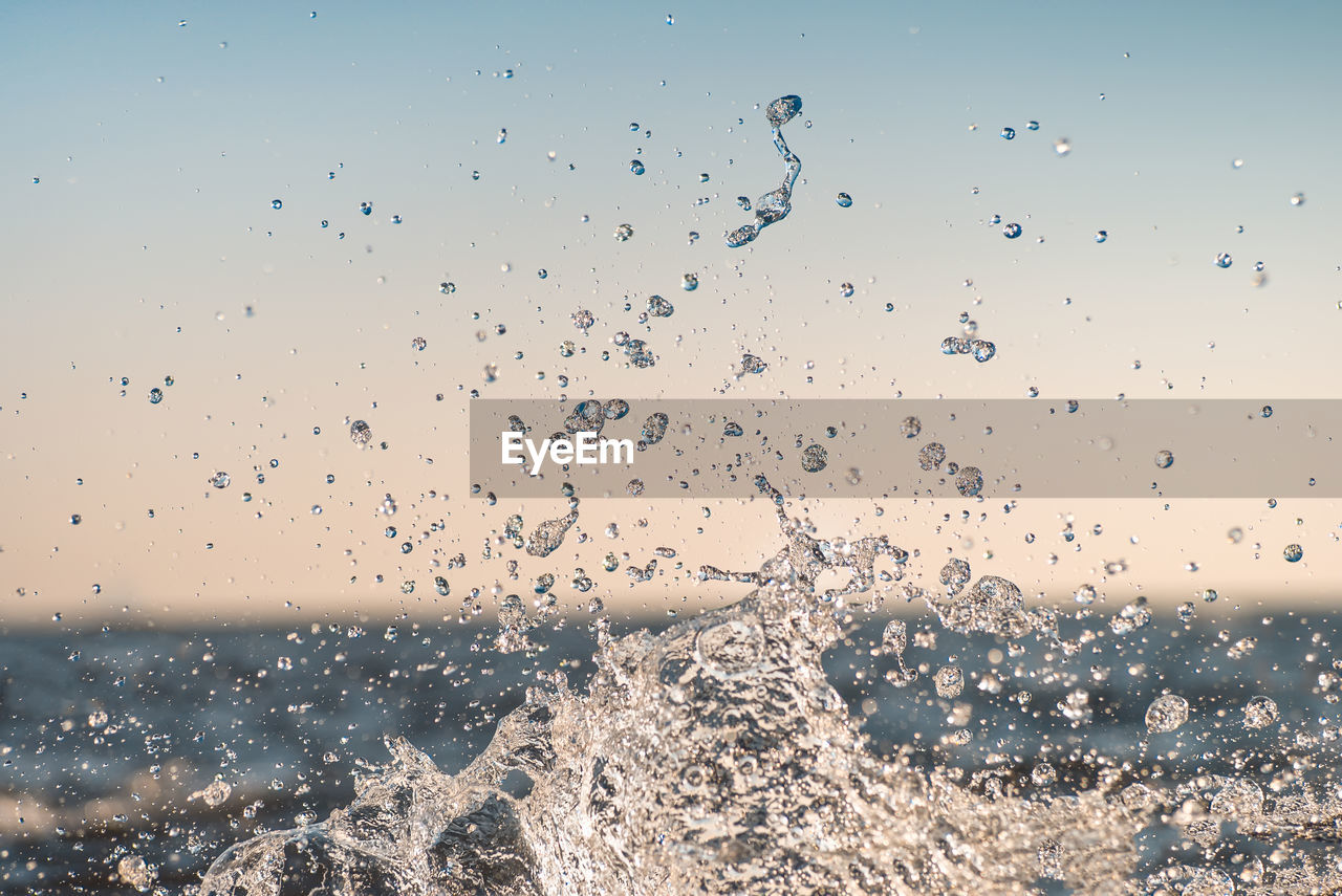 Water splashing in sea against sky