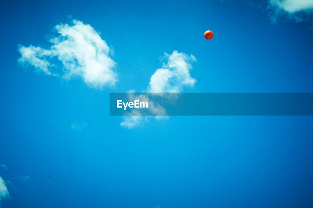 Low angle view of balloons against blue sky