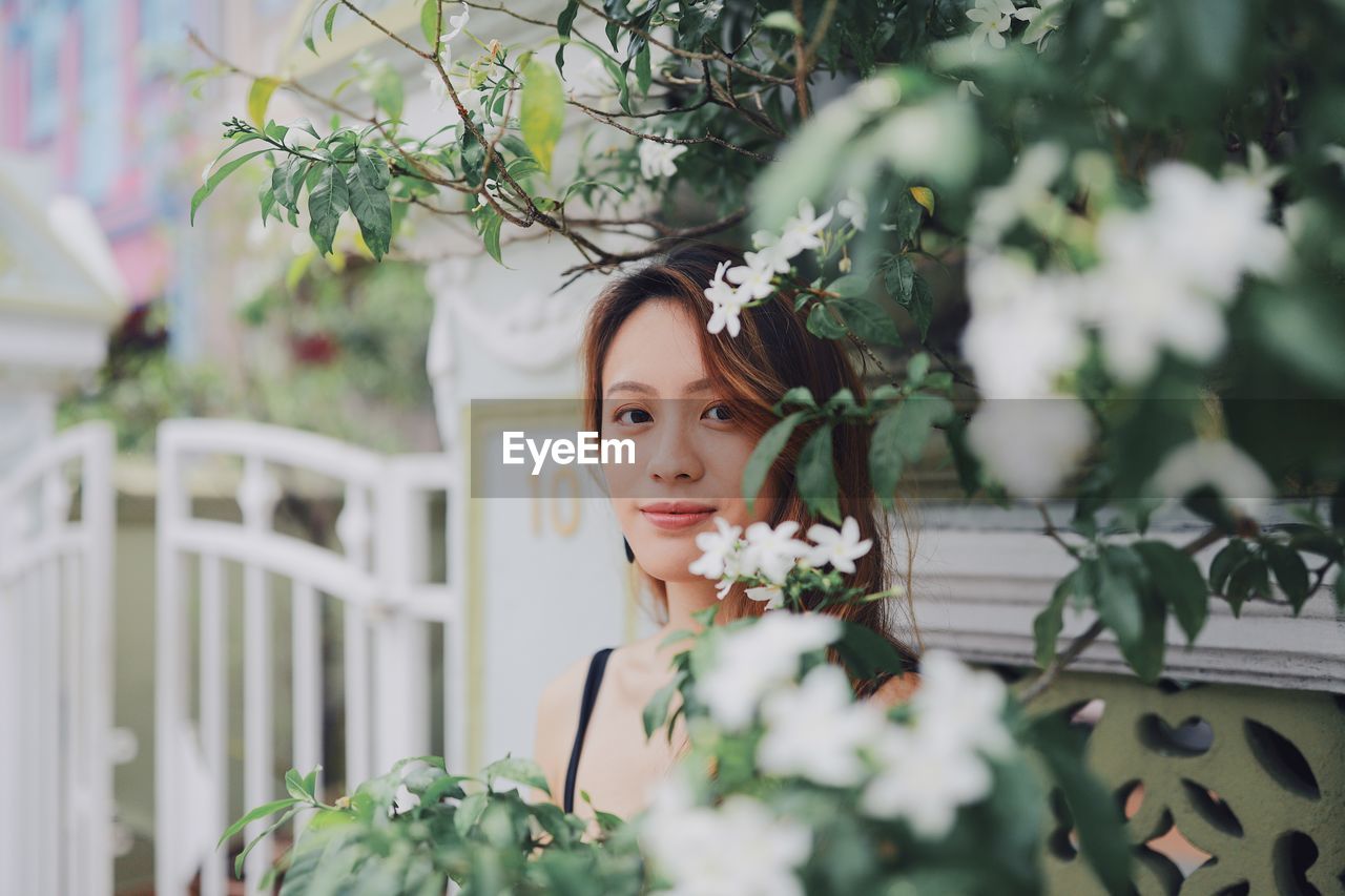 Portrait of woman by blooming flowers