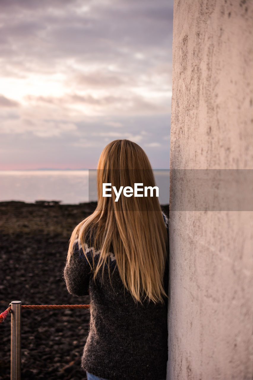 Rear view of woman looking at view during sunset
